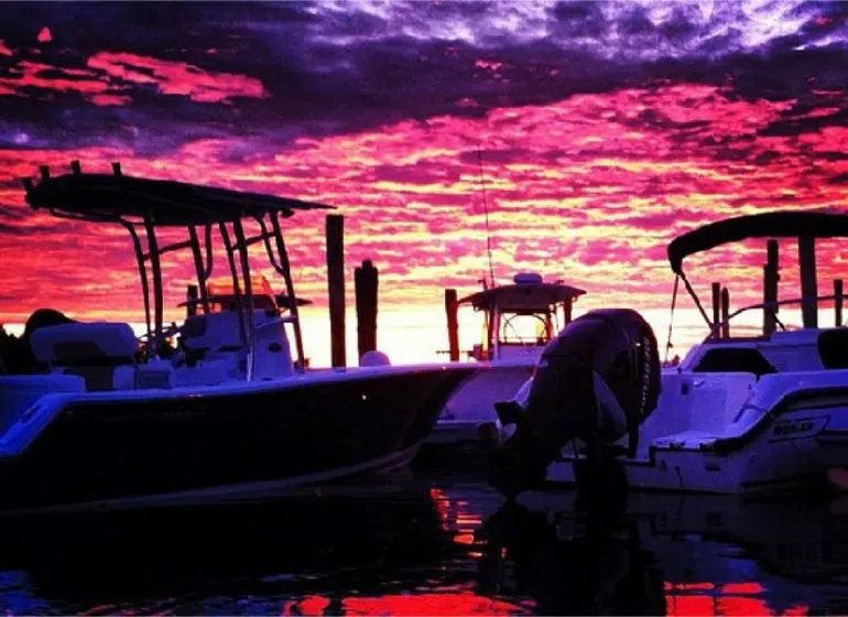 Purple and magenta sunset behind moored boats
