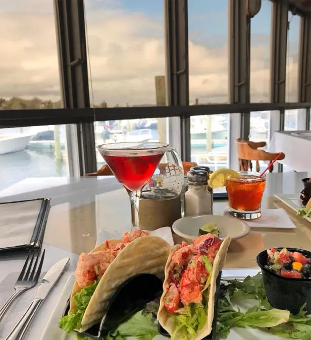 Lobster salad tacos with a cocktail beside the window